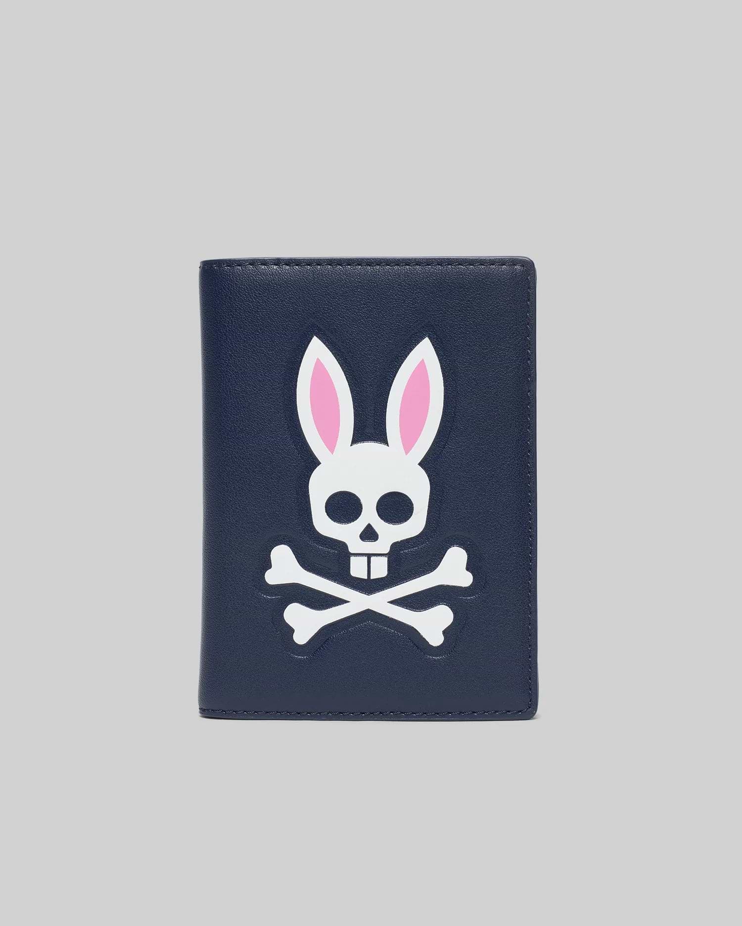 Navy Passport Holder with a large, centered white and pink Psycho Bunny skull and crossbones logo on a smooth faux leather texture.