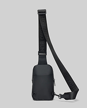 Black Mens Rubberized Crossbody bag featuring a sleek, smooth finish, an adjustable woven strap with repeated Psycho Bunny text logo, and secure zippered compartments.