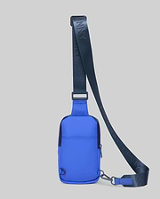 Vibrant Blue Rubberized Crossbody Bag with a smooth texture, featuring a dark navy adjustable strap with repeated Psycho Bunny text, a front zipper, D-ring, and carabiner clip.