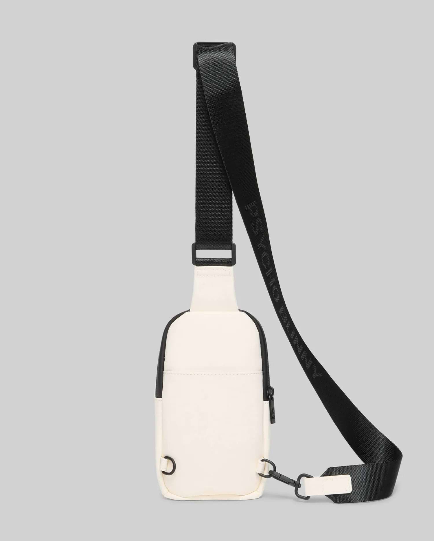 Mens Rubberized Crossbody in cream with sleek black trim, zippers, and hardware, featuring a smooth, durable texture and an adjustable black strap with repeated Psycho Bunny text branding.