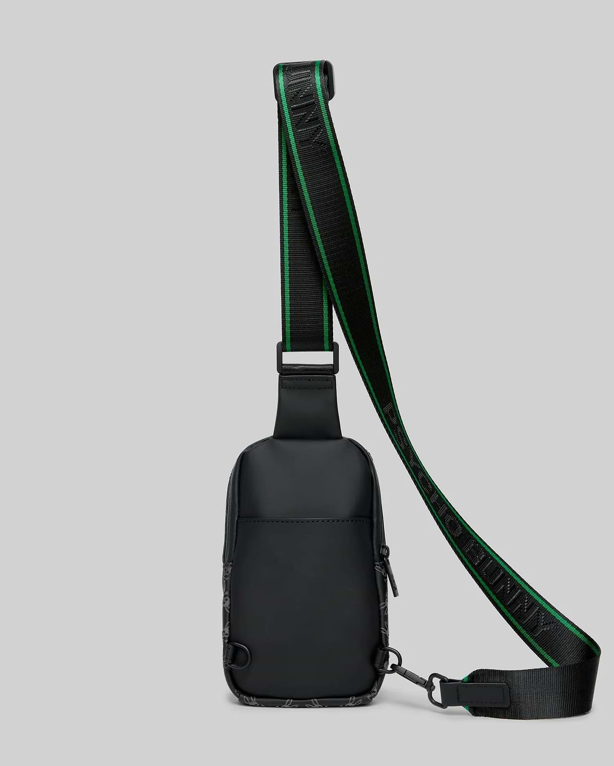 Mens Rubberized Crossbody in black, featuring a subtle all-over bunny skull pattern, a prominent green-striped strap with PSYCHO BUNNY text, and a sleek, compact design.