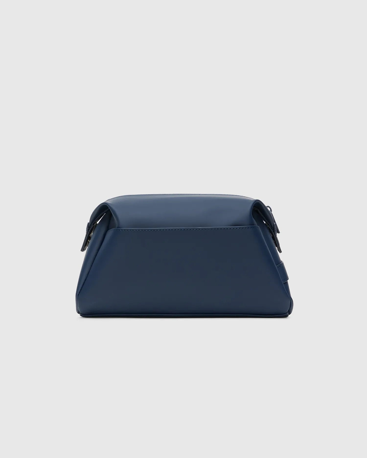 CLASSIC BUNNY TOILETRY KIT, a sleek navy blue travel bag with a smooth, matte finish. It features a structured rectangular shape, rounded edges, and a secure top flap closure, embodying refined streetwear style.