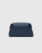 CLASSIC BUNNY TOILETRY KIT, a sleek navy blue travel bag with a smooth, matte finish. It features a structured rectangular shape, rounded edges, and a secure top flap closure, embodying refined streetwear style.