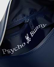 Navy blue Classic Bunny Toiletry Kit with smooth exterior, textured navy interior, zippered main compartment, internal pocket, and large white Psycho Bunny skull logo print, a small bunny skull on the zipper pull.