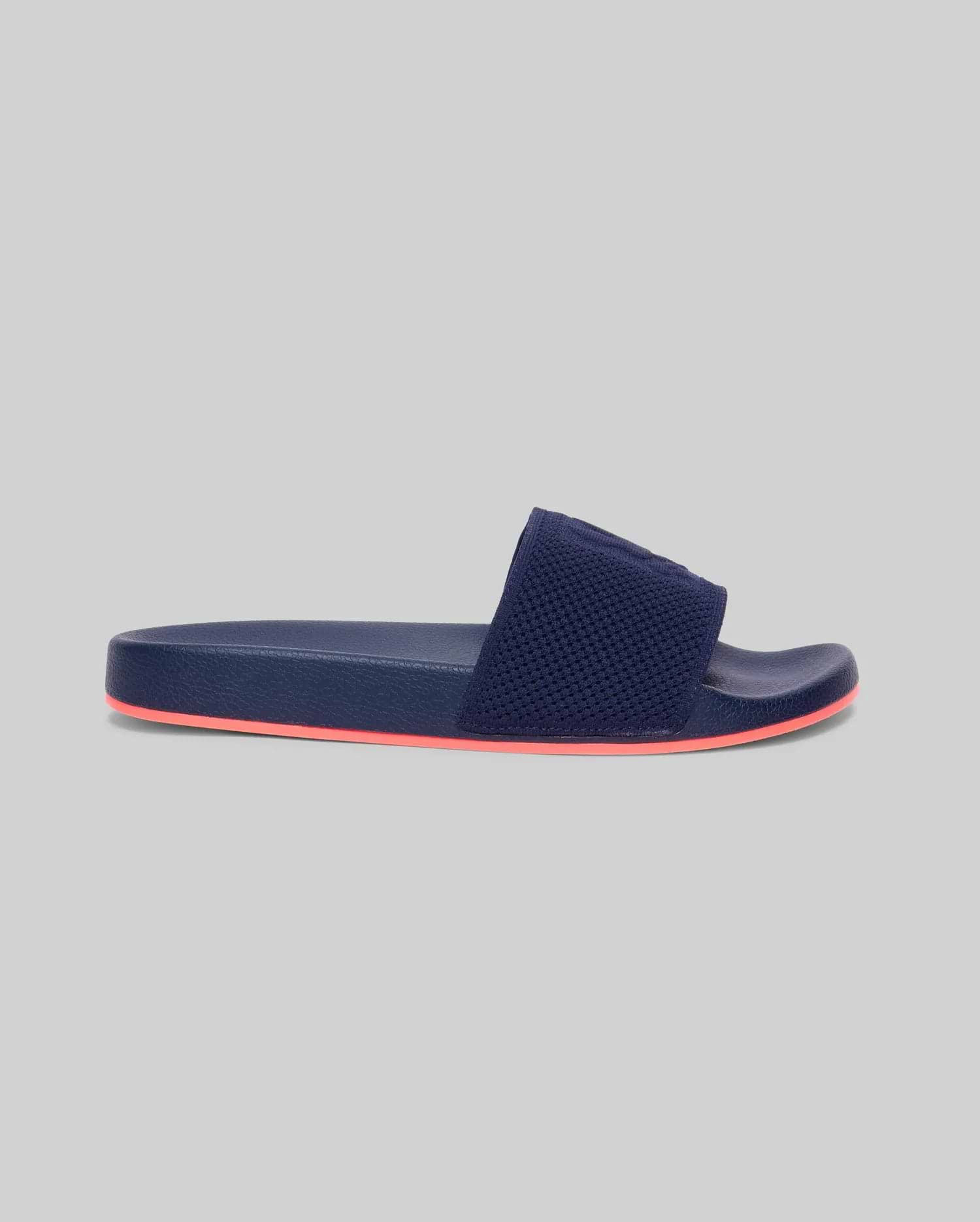 Mens Contrast Sole Knit Slides, premium Psycho Bunny footwear, in deep navy with a textured knit strap featuring subtle branding and a vibrant coral contrast sole for refined streetwear style.