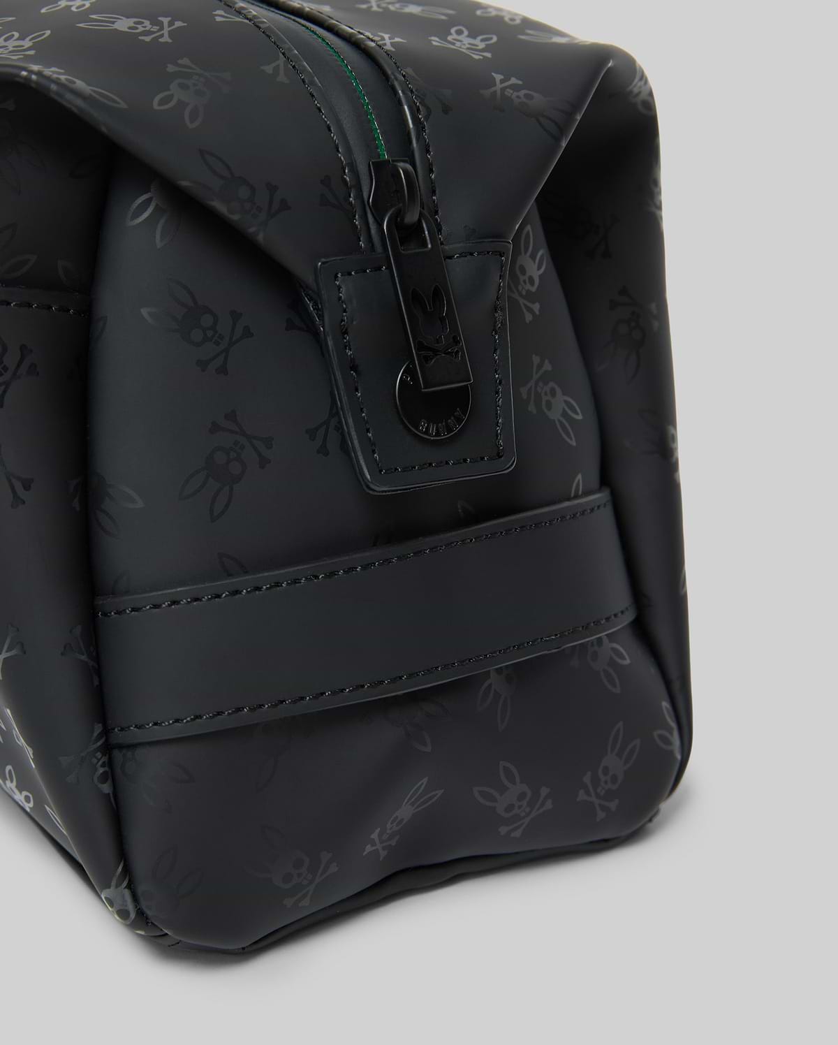 Mens All Over Bunny Toiletry Kit, black with an all-over subtle Psycho Bunny skull logo pattern, smooth texture, top zipper closure with branded pull, and a side strap.