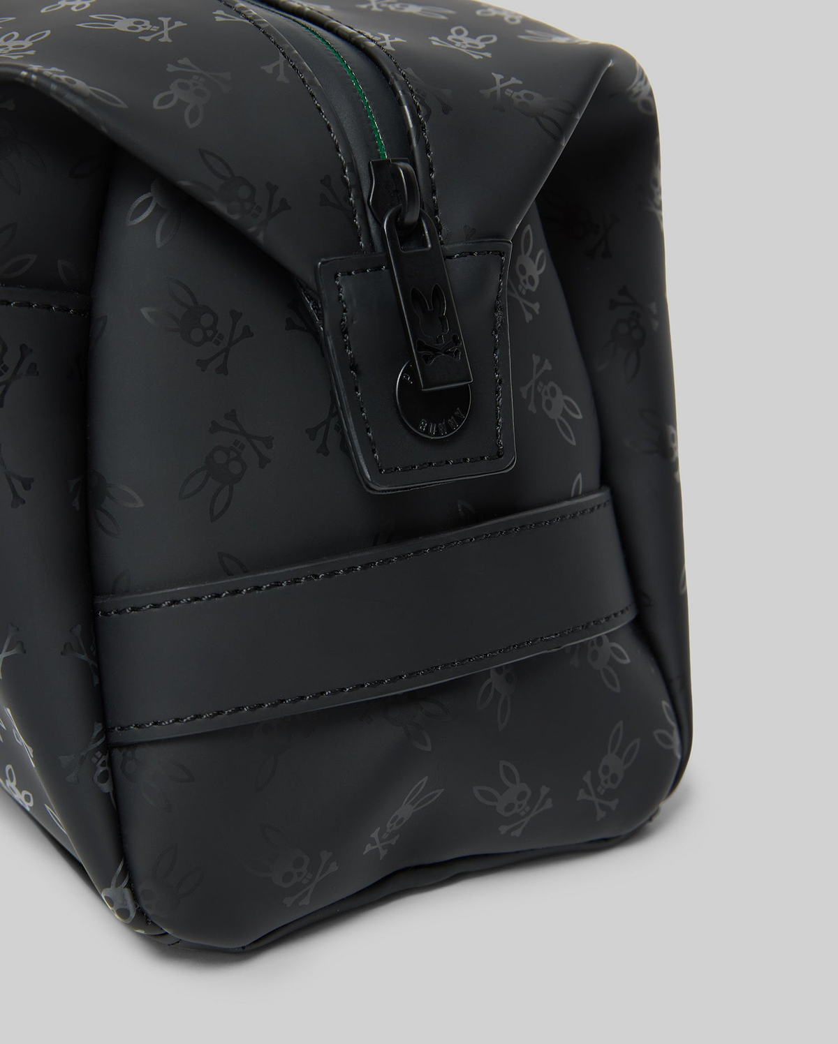 Mens All Over Bunny Toiletry Kit, black with an all-over subtle Psycho Bunny skull logo pattern, smooth texture, top zipper closure with branded pull, and a side strap.