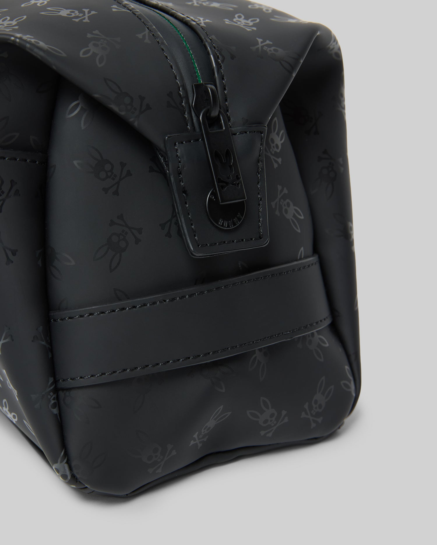 Mens All Over Bunny Toiletry Kit, black with an all-over subtle Psycho Bunny skull logo pattern, smooth texture, top zipper closure with branded pull, and a side strap.
