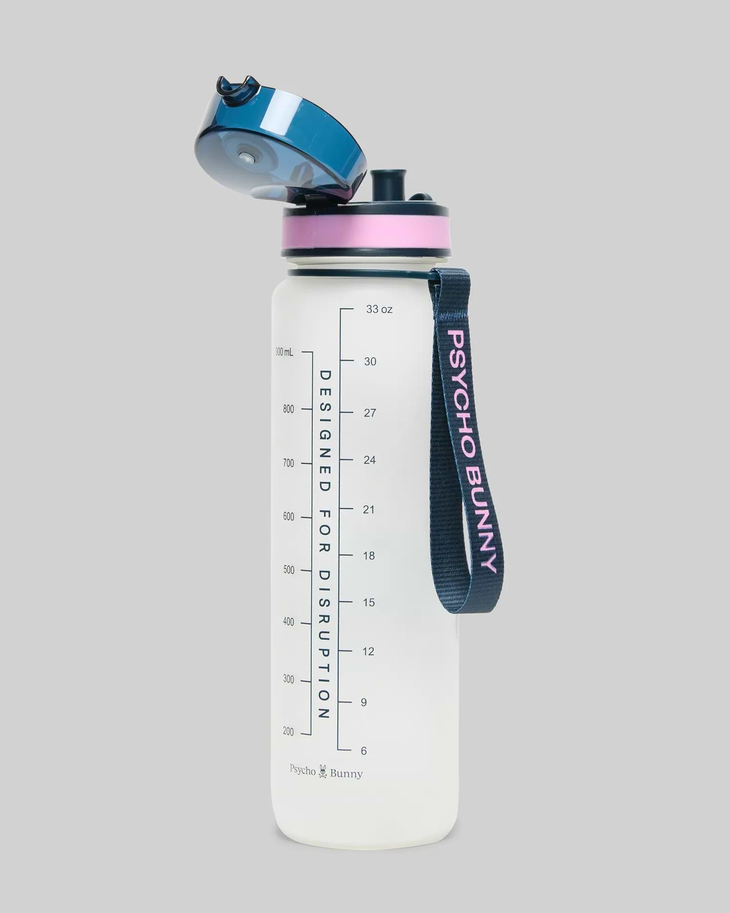 33 Oz Water Bottle, translucent white with a dark blue flip-top lid, pink accent ring, and a dark blue strap featuring pink Psycho Bunny text. It has measurement markings and Designed For Disruption text.