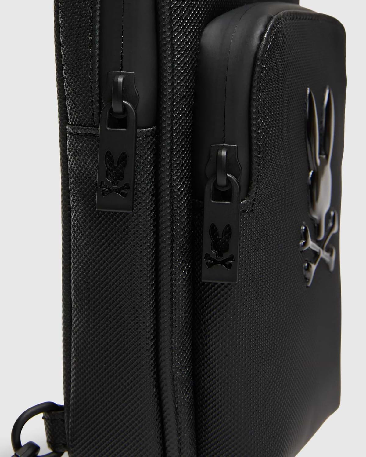 Black Crossbody Bag with durable textured fabric, featuring a prominent glossy raised Psycho Bunny skull logo and custom black zipper pulls with the logo. (3)