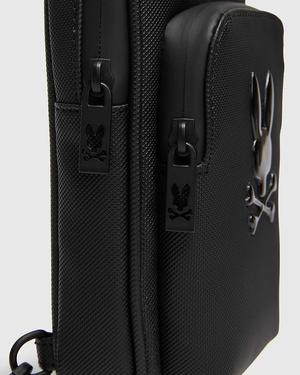 Black Crossbody Bag with durable textured fabric, featuring a prominent glossy raised Psycho Bunny skull logo and custom black zipper pulls with the logo. (3)