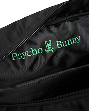 Black Mens Nylon Duffle Bag interior with a large, vibrant green Psycho Bunny text and iconic skull logo printed on the smooth, subtly textured nylon lining, next to a black zipper. (3)