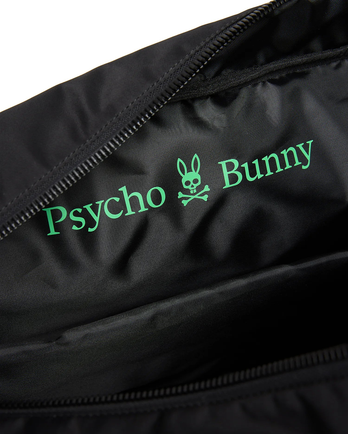 Black Mens Nylon Duffle Bag interior with a large, vibrant green Psycho Bunny text and iconic skull logo printed on the smooth, subtly textured nylon lining, next to a black zipper. (3)