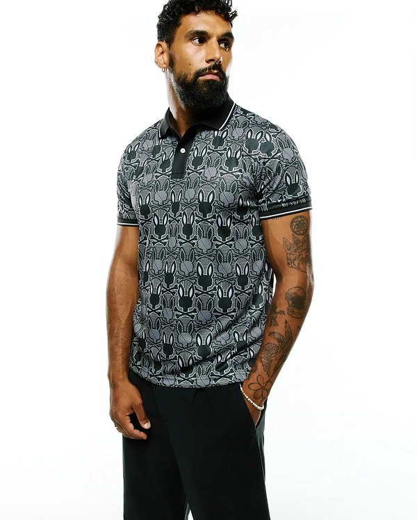 Mens Reeves All Over Bunny Sport Polo, a black and white all-over bunny skull pattern polo shirt with a classic fit, smooth performance fabric, black collar, and white striped cuffs.