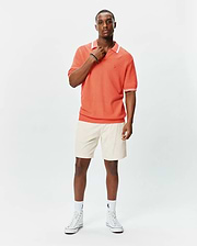 Mens Innis Polo in vibrant coral pique knit, featuring a classic fit, white collar with thin stripe, white sleeve cuffs with thin stripe, and a small embroidered Psycho Bunny skull logo on the left chest. (3)