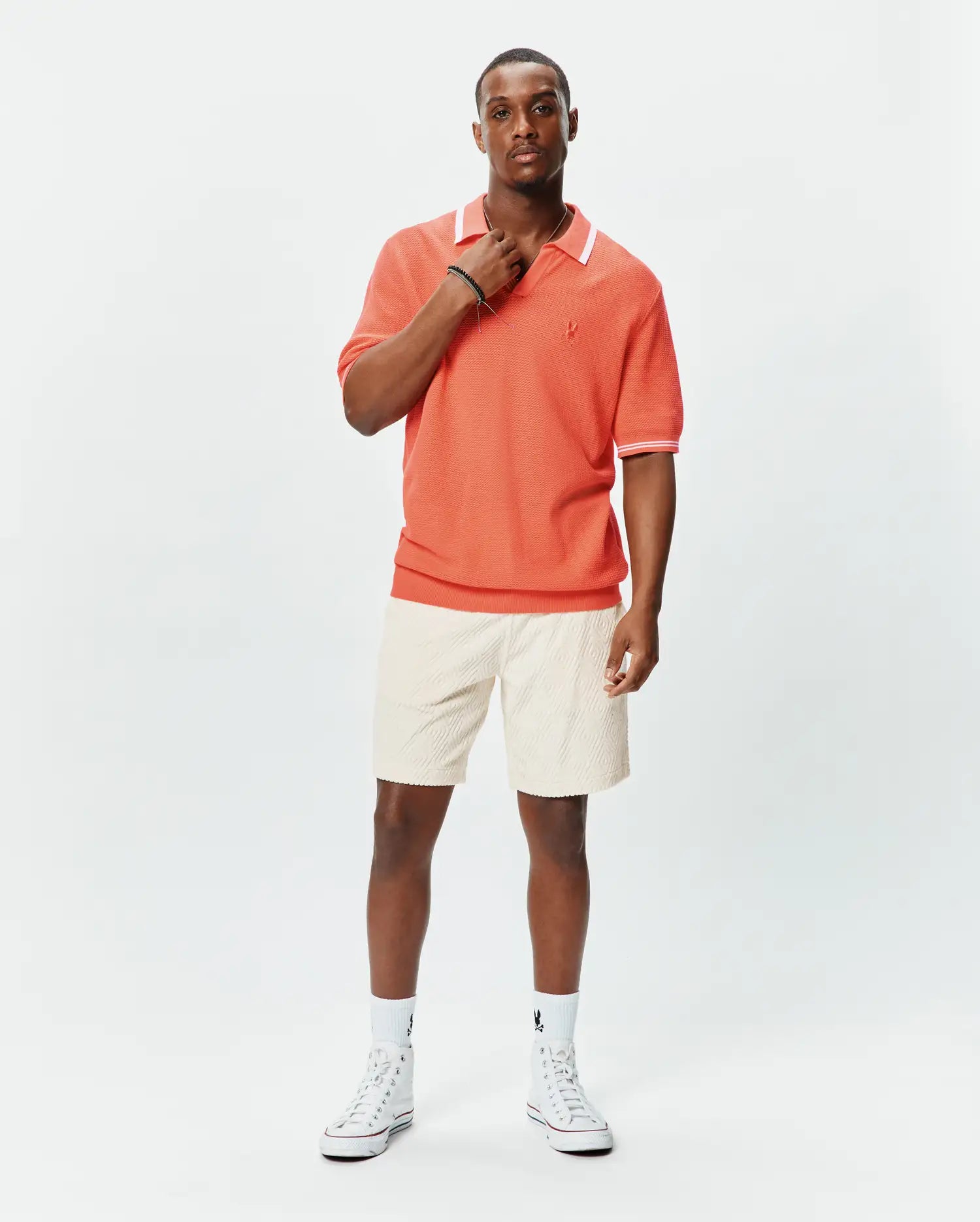 Mens Innis Polo in vibrant coral pique knit, featuring a classic fit, white collar with thin stripe, white sleeve cuffs with thin stripe, and a small embroidered Psycho Bunny skull logo on the left chest. (3)
