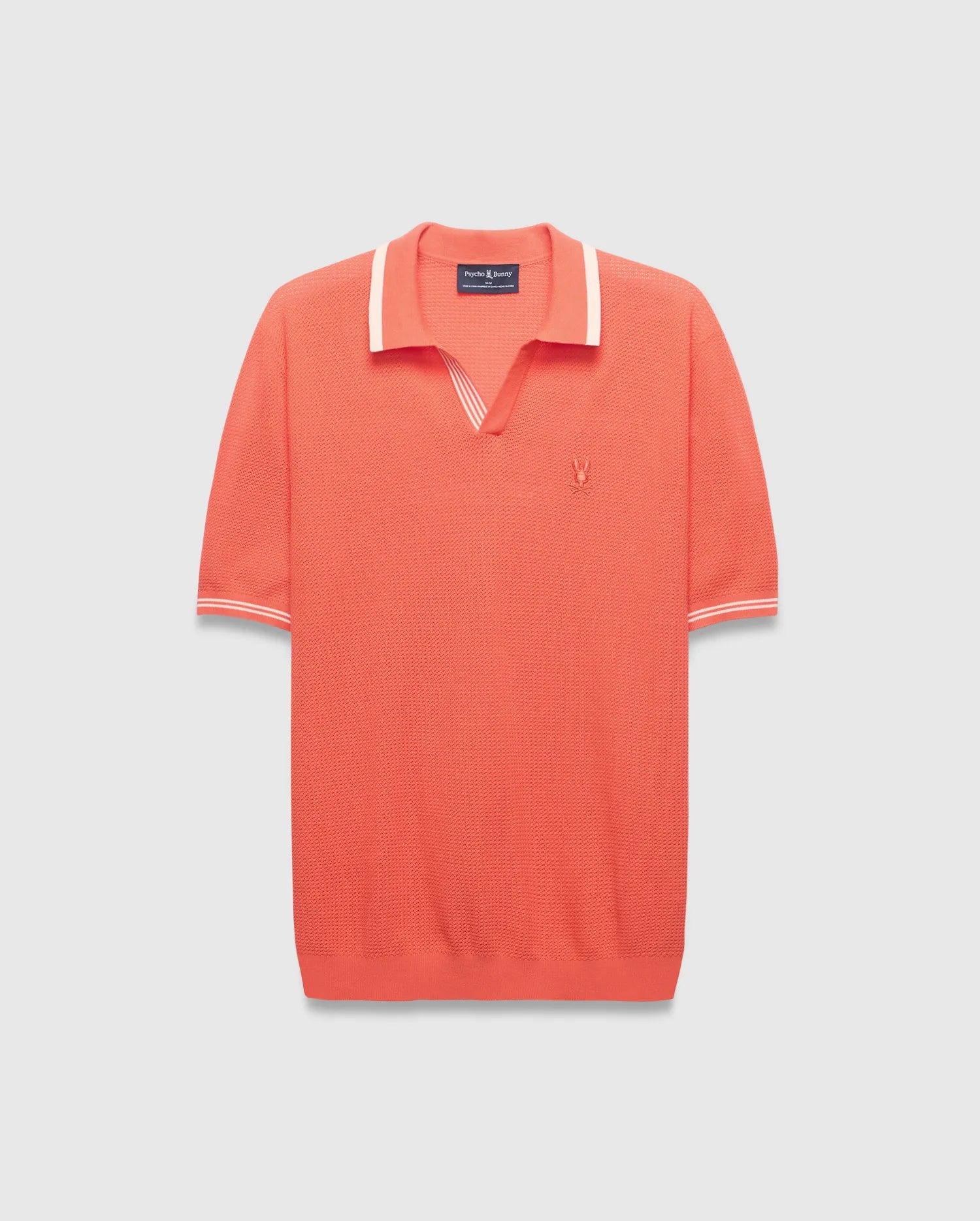 Mens Innis Polo, a vibrant coral knit polo with a V-neck collar and cuffs accented by white stripes, featuring a small embroidered Psycho Bunny skull logo on the left chest. Classic fit. (4)