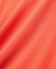 Mens Innis Polo in vibrant coral orange pique knit fabric, showcasing its signature textured, breathable weave with subtle diagonal folds, ideal for premium Psycho Bunny refined streetwear. (5)