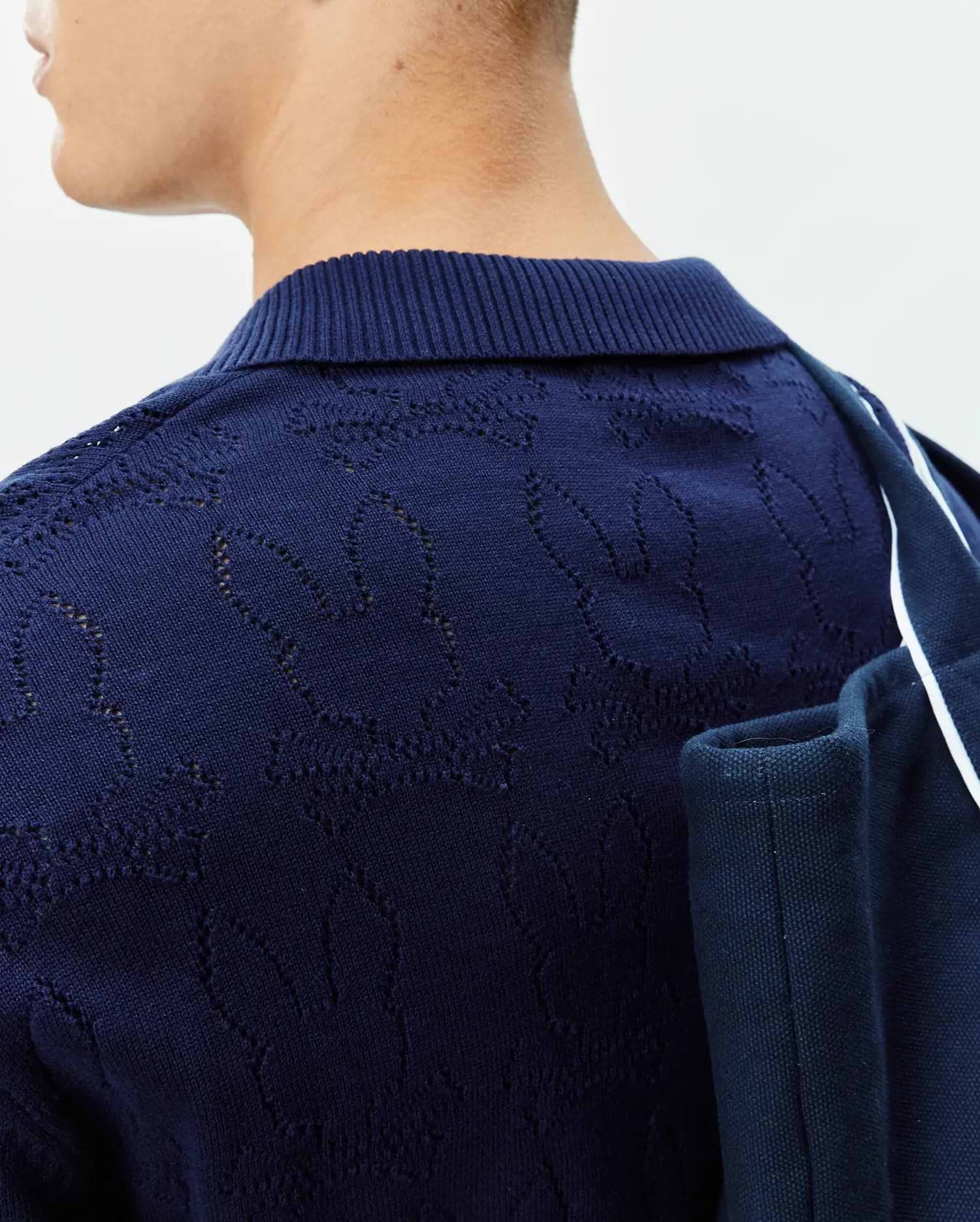 Mens Harold Pointelle All Over Bunny Knit Polo, a navy blue knit polo featuring an all-over pointelle bunny skull pattern and a ribbed collar.