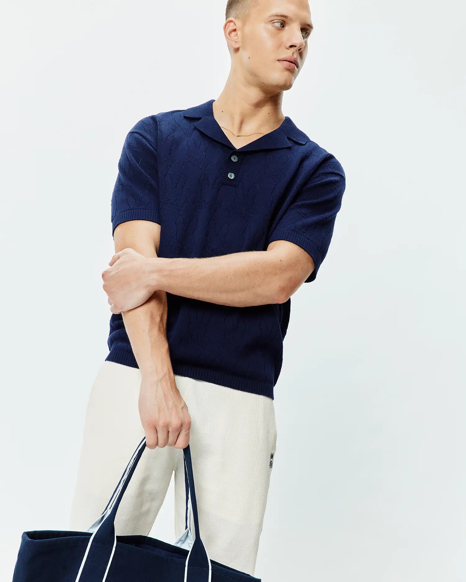 Mens Harold Pointelle All Over Bunny Knit Polo in navy blue, featuring a subtle all-over bunny pointelle knit pattern, an open collar, and two light blue buttons, in a classic fit.