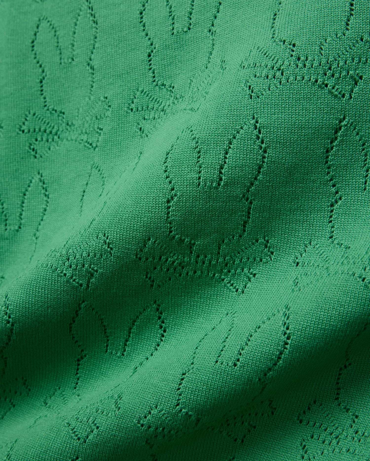 Mens Harold Pointelle All Over Bunny Knit Polo in vibrant emerald green, showcasing a refined all-over pointelle knit pattern of the iconic Psycho Bunny skull logo, creating a textured finish.