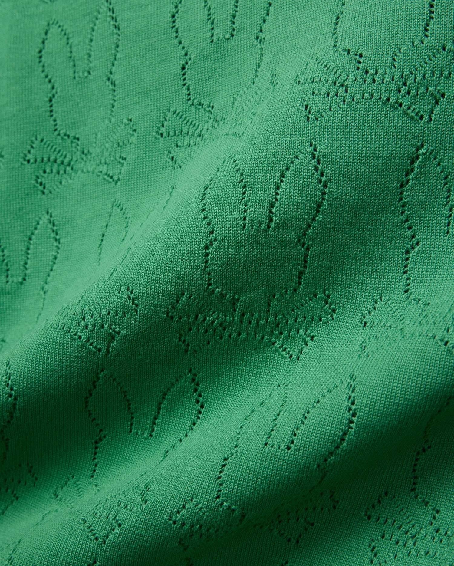 Mens Harold Pointelle All Over Bunny Knit Polo in vibrant emerald green, showcasing a refined all-over pointelle knit pattern of the iconic Psycho Bunny skull logo, creating a textured finish.