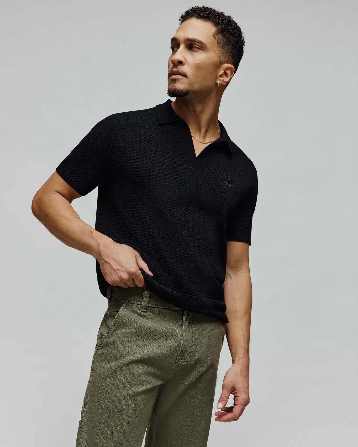 Black Mens Devon Knit Polo, a classic fit short-sleeve textured knit polo featuring a small, tonal embroidered Psycho Bunny skull logo on the left chest.