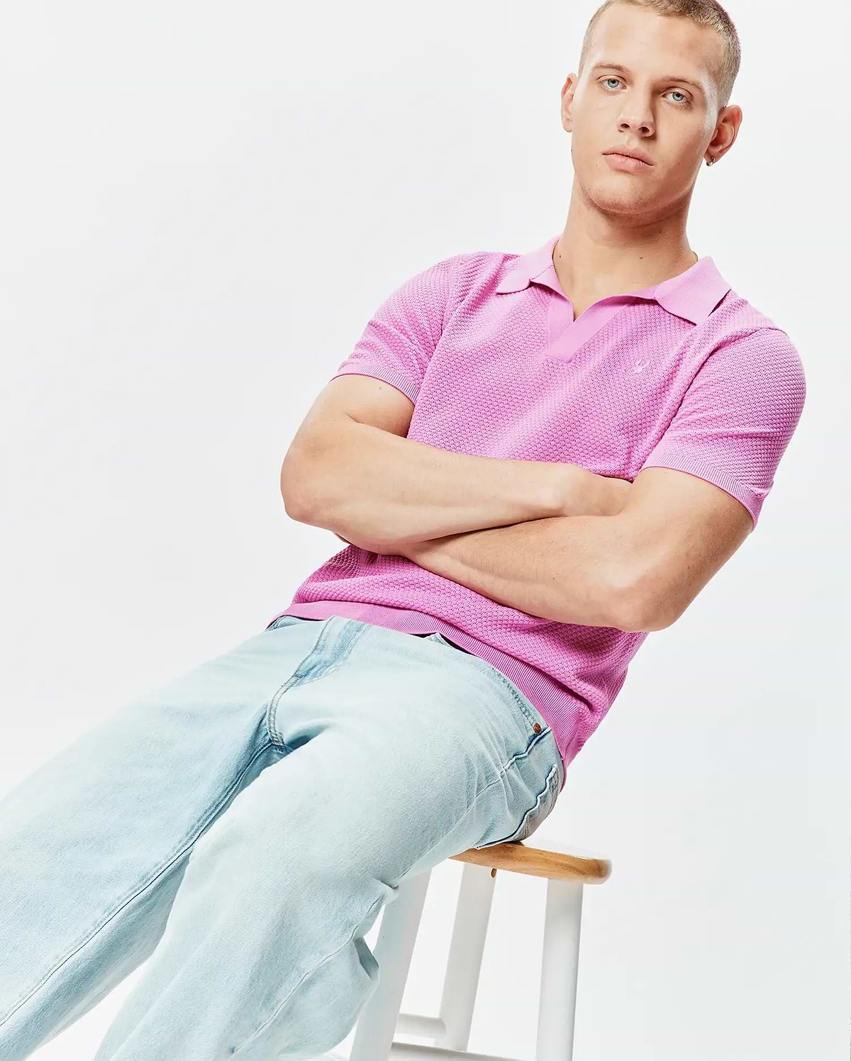 Mens Devon Knit Polo in vibrant pink, featuring a textured knit fabric, V-neck collar, ribbed cuffs and hem, with a small embroidered Psycho Bunny skull logo on the left chest.