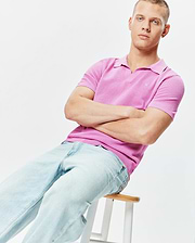 Mens Devon Knit Polo in vibrant pink, featuring a textured knit fabric, V-neck collar, ribbed cuffs and hem, with a small embroidered Psycho Bunny skull logo on the left chest.