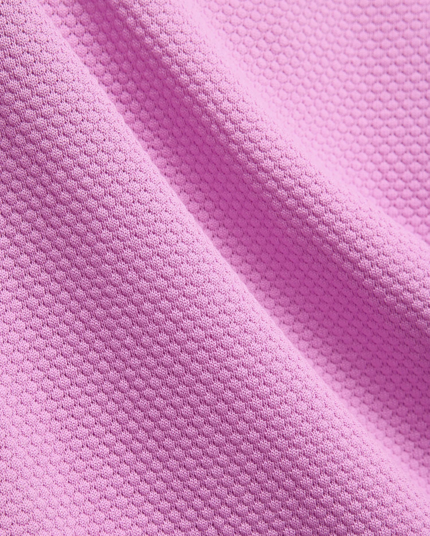 Mens Devon Knit Polo, a premium vibrant fuchsia pink polo shirt crafted from a refined, breathable pique knit fabric, showcasing its distinctive textured pattern.