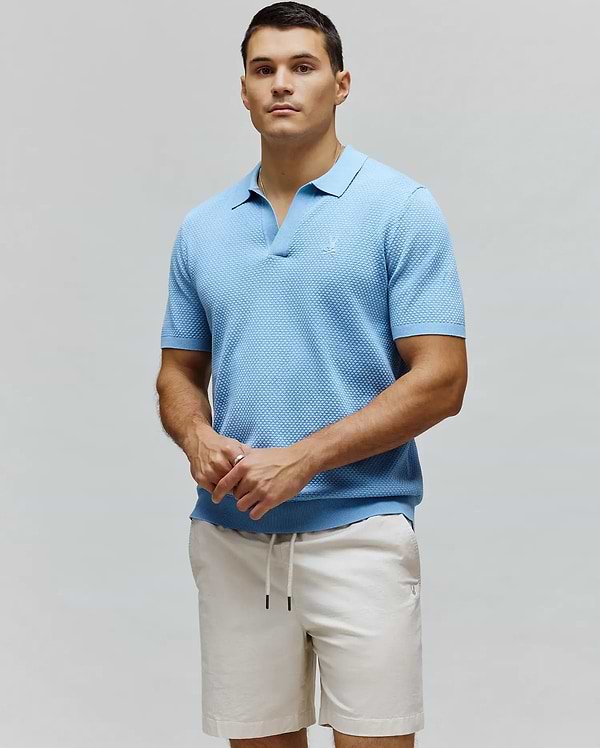 MENS DEVON KNIT POLO in sky blue, a classic fit, short-sleeve polo with a textured knit fabric, open collar, and a small, tonal embroidered Psycho Bunny skull logo on the left chest.