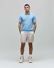 Mens Devon Knit Polo, a light blue classic fit textured knit polo featuring an open collar and a small, distinct white embroidered Psycho Bunny skull logo on the left chest.
