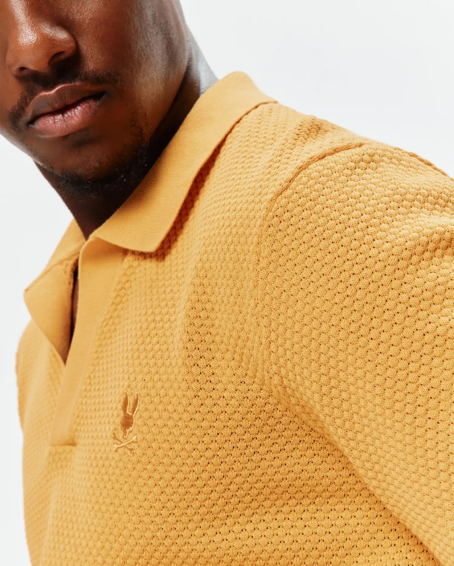 Mens Devon Knit Polo in golden yellow, featuring a textured pique knit fabric and a small, embroidered Psycho Bunny skull logo on the left chest.