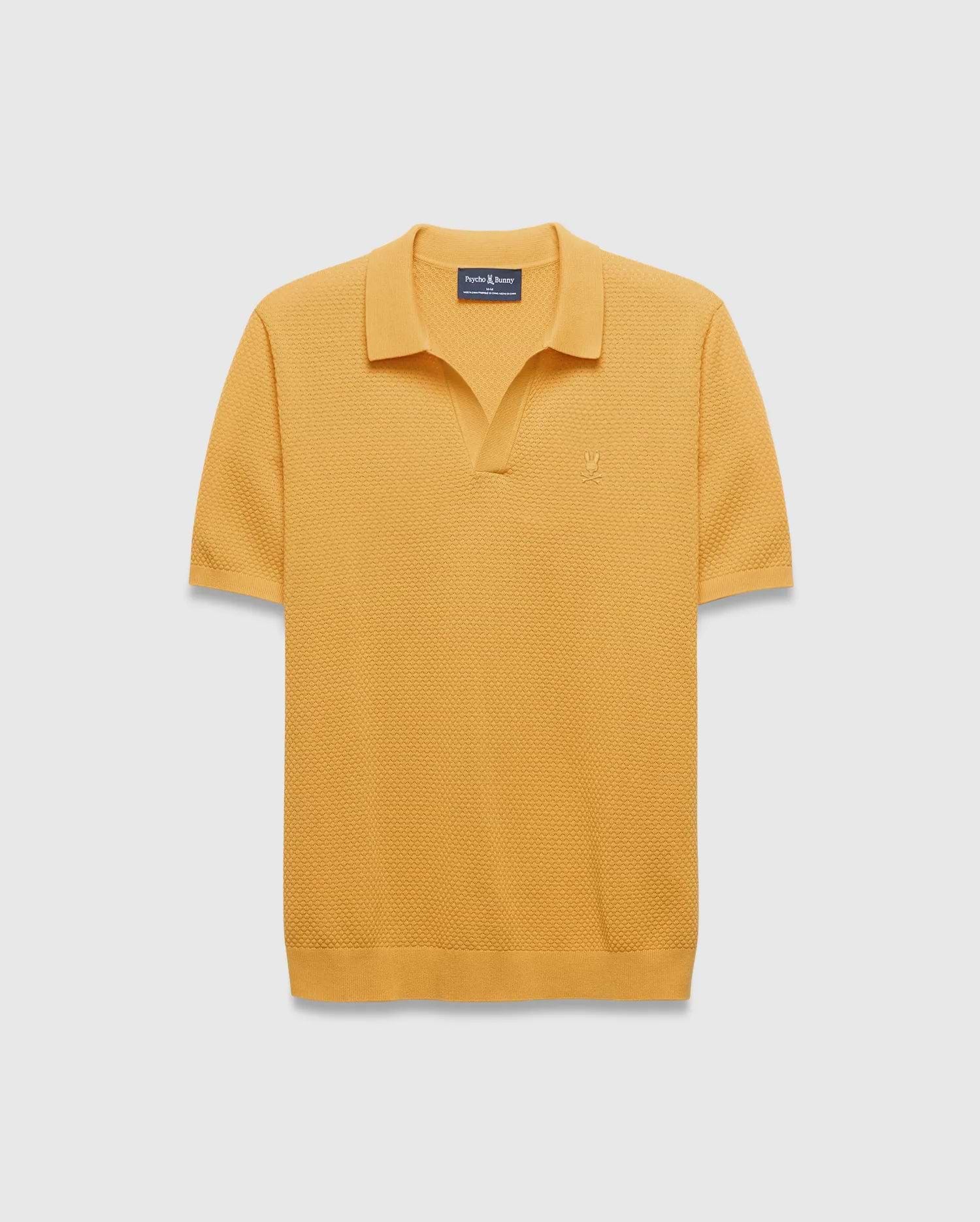 Mens Devon Knit Polo in mustard yellow, featuring a textured waffle knit fabric, classic fit, spread collar, V-neck placket, and a small embroidered Psycho Bunny skull logo on the left chest.