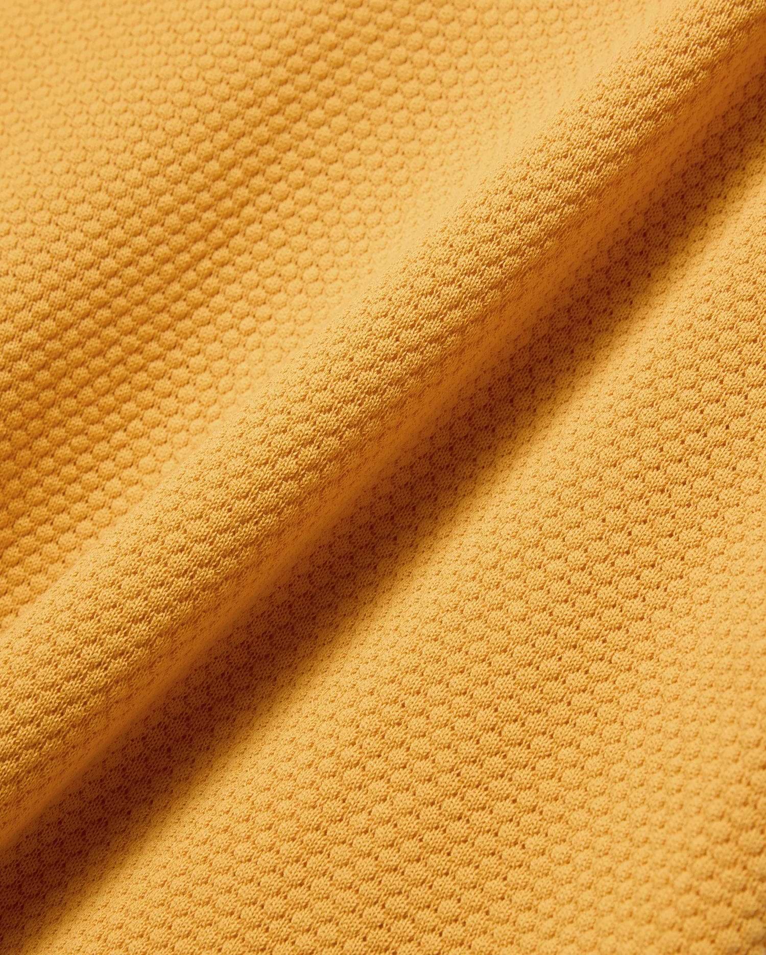 Mens Devon Knit Polo in vibrant gold, featuring a textured pique knit fabric and the signature embroidered Psycho Bunny skull logo on the left chest.