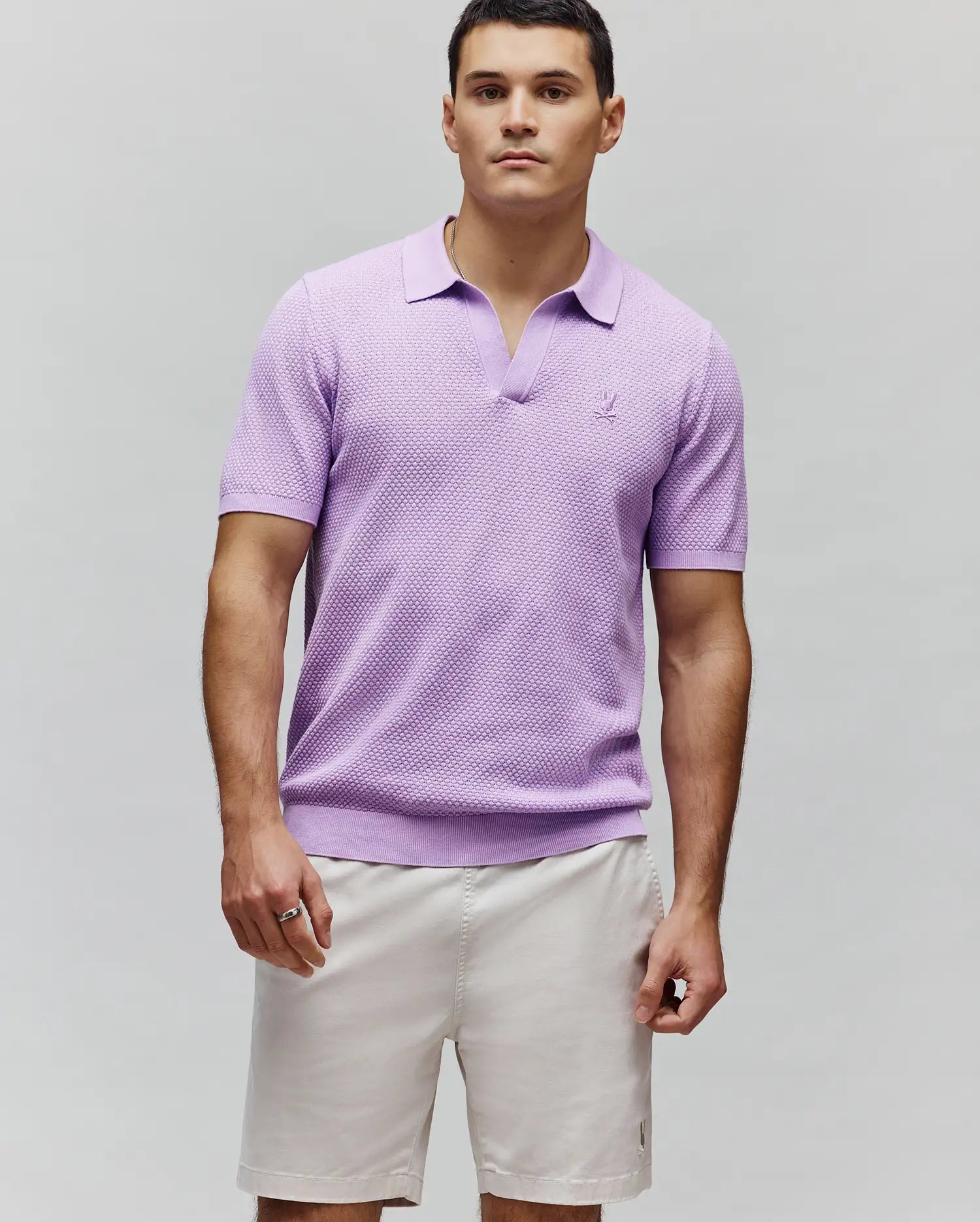 Lavender Mens Devon Knit Polo with a classic fit, textured knit fabric, V-neck, ribbed collar, cuffs, and hem, featuring a small embroidered Psycho Bunny skull logo on the left chest.