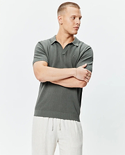 Mens Devon Knit Polo in deep olive, featuring a textured knit fabric, open collar, ribbed cuffs and hem, with a small embroidered Psycho Bunny skull logo on the left chest.