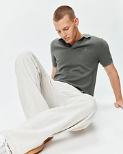 Mens Devon Knit Polo in charcoal green, a classic fit, textured mini-waffle knit fabric, with a small embroidered silver Psycho Bunny skull logo on the left chest.