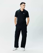 Mens Edwin Sport Polo, black pique knit polo shirt with a classic fit, featuring white piping on the collar and sleeve cuffs, and a small white embroidered Psycho Bunny skull logo on the left chest.