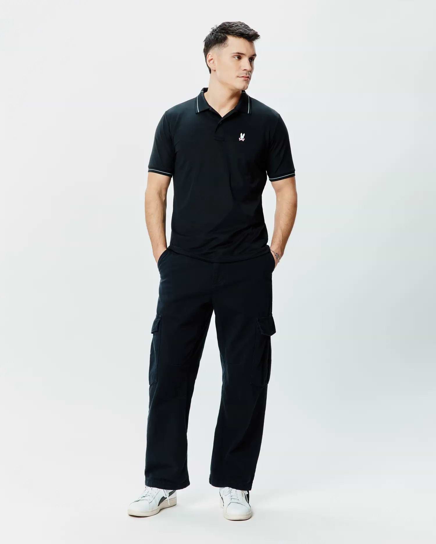 Mens Edwin Sport Polo, black pique knit polo shirt with a classic fit, featuring white piping on the collar and sleeve cuffs, and a small white embroidered Psycho Bunny skull logo on the left chest.