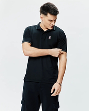 Mens Edwin Sport Polo, a classic fit black pique knit polo shirt with white tipping on the collar and cuffs, featuring a small embroidered pink, white, and light blue Psycho Bunny skull logo on the left chest.