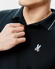 Mens Edwin Sport Polo, black pique knit with a classic fit, featuring a light blue collar stripe and an embroidered mint green and pink Psycho Bunny skull logo on the left chest.