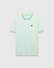 Mens Edwin Sport Polo, a classic fit light green pique polo with a black and orange striped collar, matching black striped cuffs, and a small embroidered Psycho Bunny skull logo on the left chest.