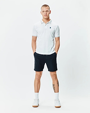 Mens Edwin Sport Polo, a classic fit white pique polo with navy tipping on the collar and cuffs, featuring a small embroidered teal Psycho Bunny skull logo on the left chest.