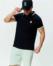 Mens Holden Pique Polo, a black classic fit pique knit polo with white and grey tipping on the collar and sleeve cuffs, featuring a small embroidered Psycho Bunny skull logo on the left chest.