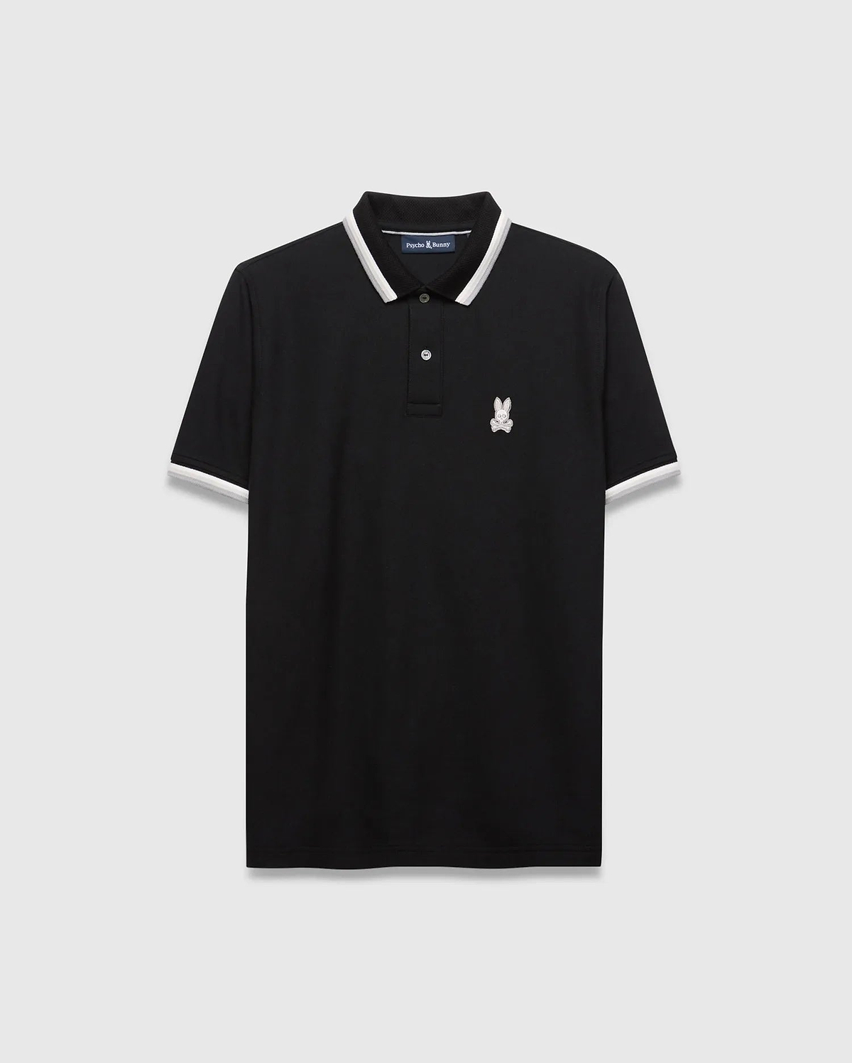 Mens Holden Pique Polo, a classic fit black pique polo shirt with white and grey striped collar and cuffs, featuring a small embroidered white Psycho Bunny skull logo on the left chest.