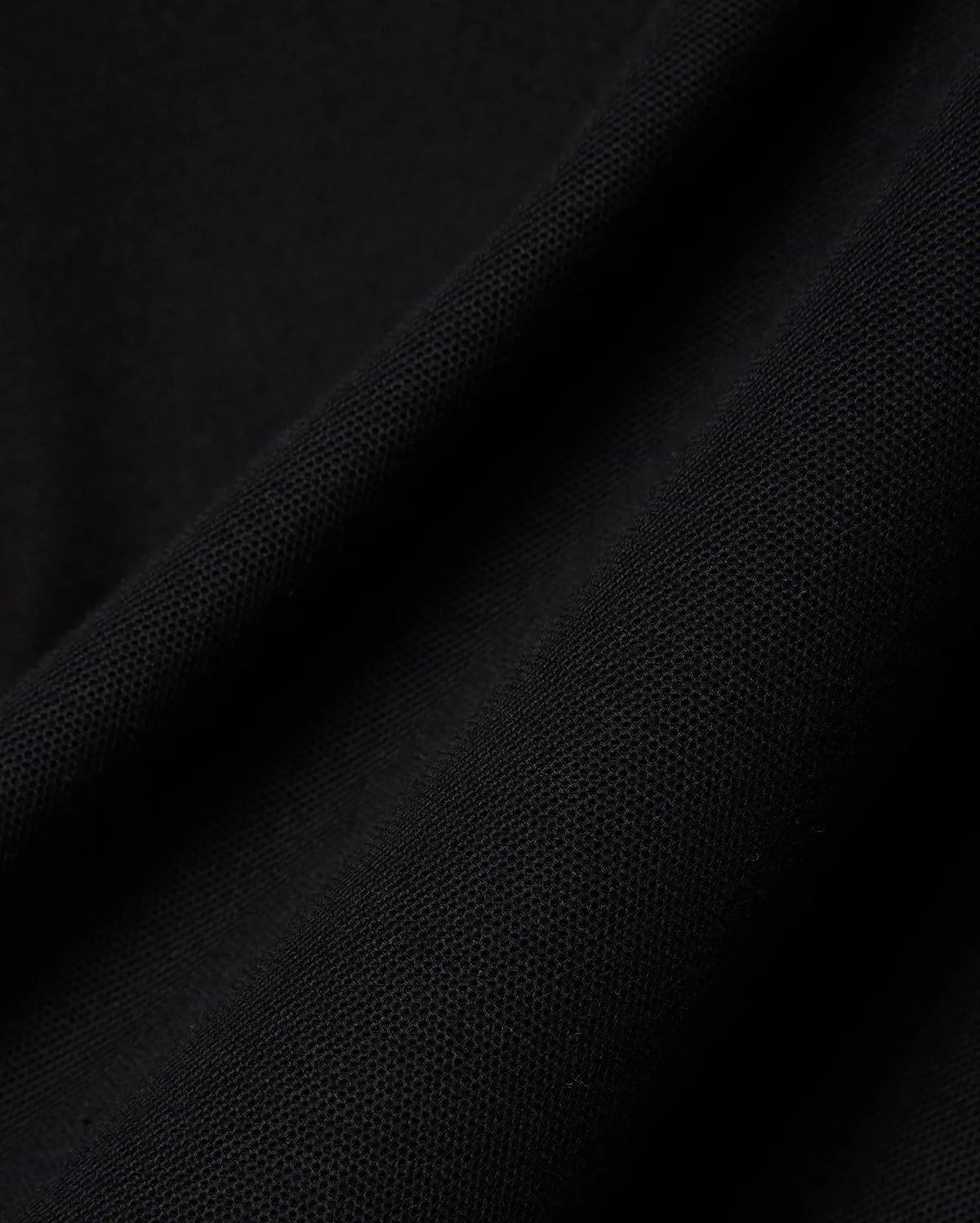 Close-up of the rich black pique fabric for the Mens Holden Pique Polo, highlighting its refined, textured weave and premium quality, characteristic of Psycho Bunny's sophisticated streetwear.