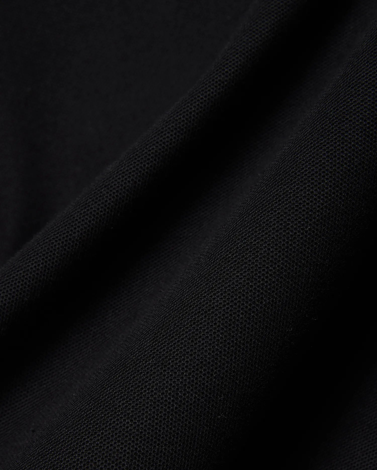 Close-up of the rich black pique fabric for the Mens Holden Pique Polo, highlighting its refined, textured weave and premium quality, characteristic of Psycho Bunny's sophisticated streetwear.