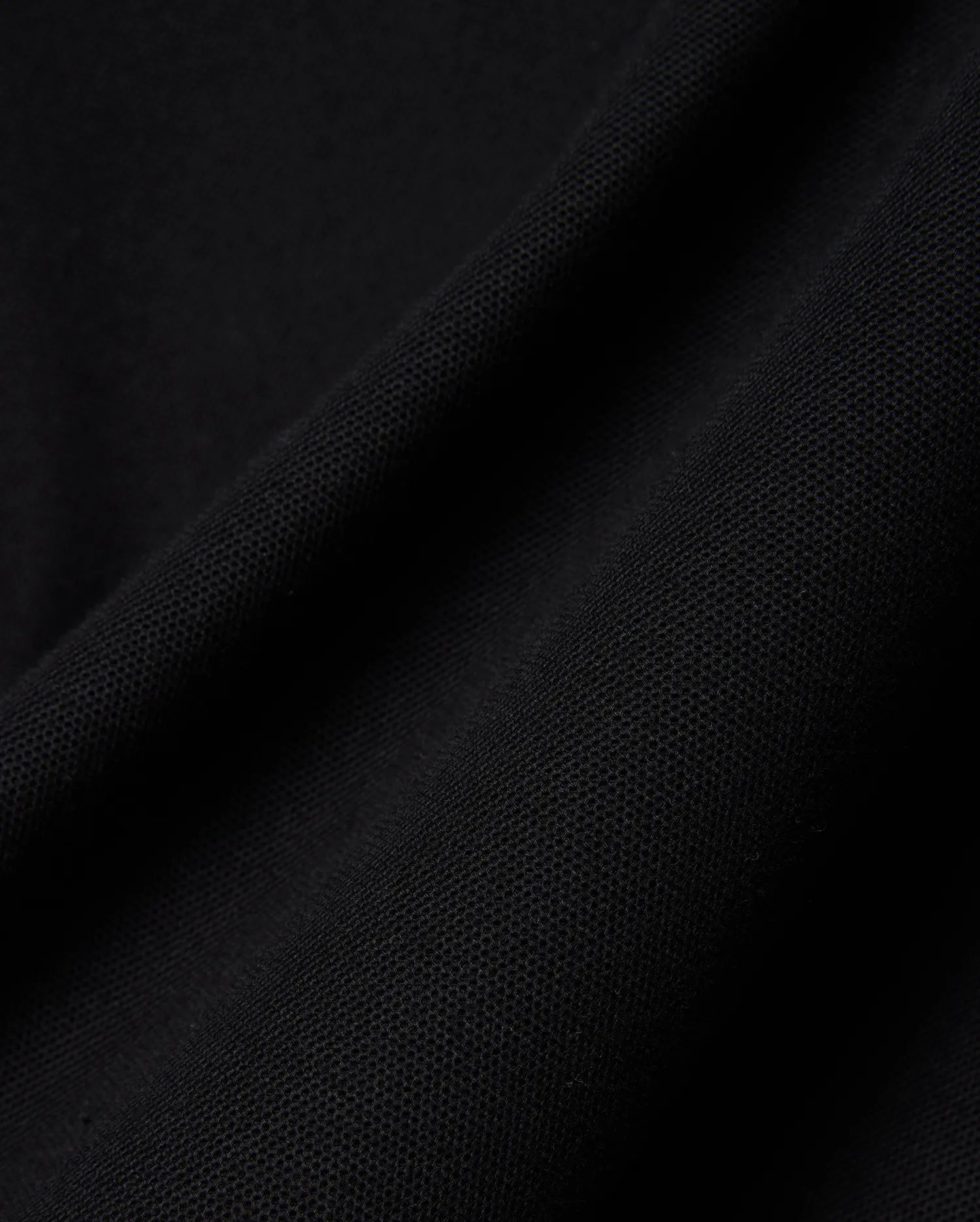 Close-up of the rich black pique fabric for the Mens Holden Pique Polo, highlighting its refined, textured weave and premium quality, characteristic of Psycho Bunny's sophisticated streetwear.