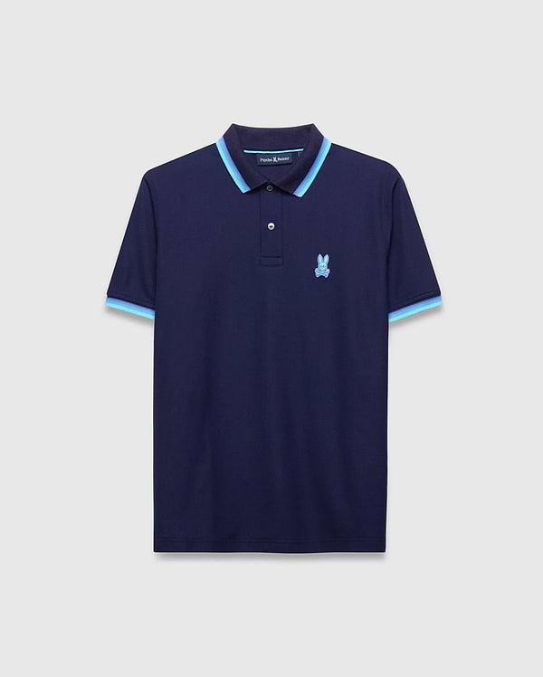 Mens Holden Pique Polo, navy classic fit pique knit with light blue and darker blue striped collar and cuffs, featuring a small embroidered light blue Psycho Bunny skull logo on the left chest.